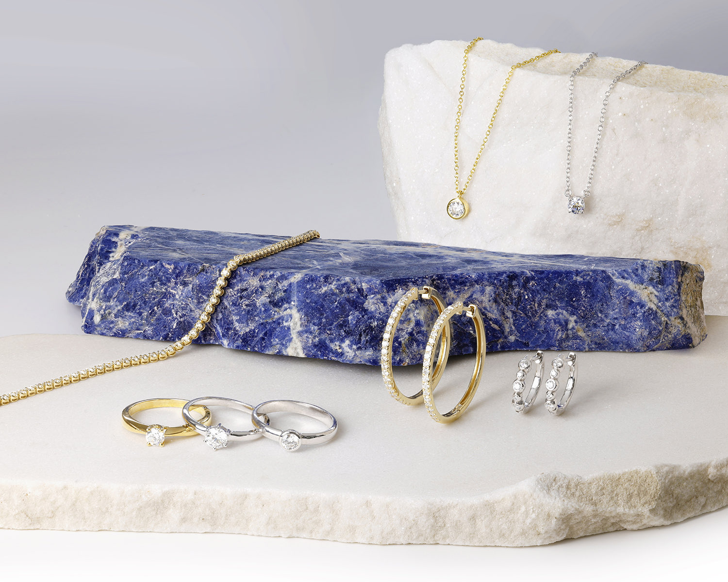 Colliers, Creolen und Ringe mit synthetischen Diamanten – inszeniert auf Rohstein